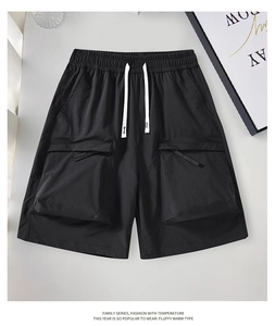 Detail of black cargo shorts featuring drawstring waist and large utility pockets