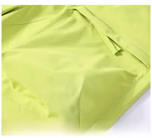 Macro detail of large side cargo pocket on fluorescent green ripstop fabric shorts