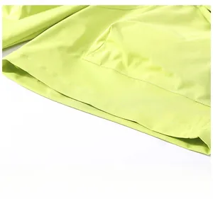 Detail of lime green cargo shorts featuring double-needle stitching on the wide-leg hem