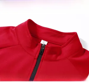 Close-up of red sports jacket with stand-up collar, black zipper and raglan sleeve design