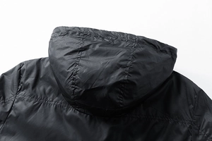 Detail view of the black hooded jacket showing fine stitching and durable nylon texture
