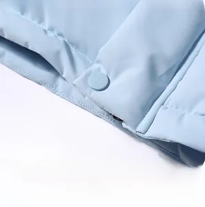 Detail view of stylish buttons and side pockets on a light blue quilted winter jacket
