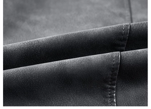 Détail de la texture cuir PU noir mat de haute qualité avec coutures précises sur une veste