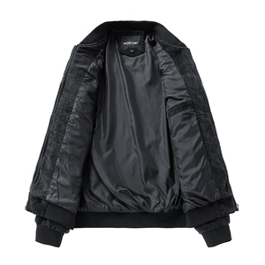 Close-up of the internal label and collar detail on the black cotton-linen bomber jacket