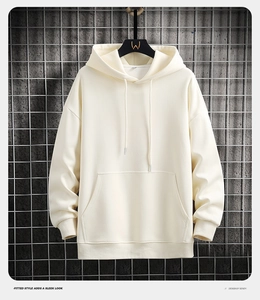 Detail of the cream-colored hoodie showing ribbed cuffs and drawstring hood on a metal hanger