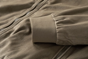 Detail of waffle knit fabric and ribbed cuffs on khaki brown suede jacket zipper coat