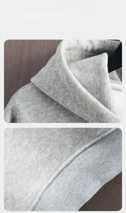 Close-up of grey knit hoodie showing fine stitching and elastic ribbed hem detail