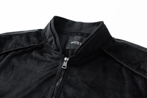 Detail of a black zip-up sports jacket featuring a stand collar and textured knit fabric