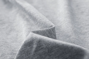 Macro shot of heather grey knitted fabric texture showing soft weave and fiber detail