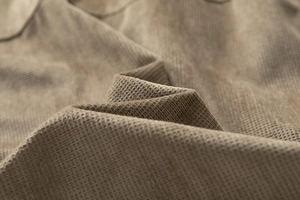 Close-up of deep brown suede jacket fabric showing detailed waffle weave texture