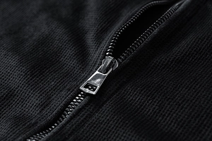 Detailed macro shot of high-quality silver-black metal zipper on waffle knit fabric