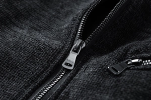 Macro shot of silver metal zipper on premium black waffle texture fabric jacket
