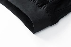 Detailed close-up of the black suede jacket with ribbed cuff and honeycomb knit texture