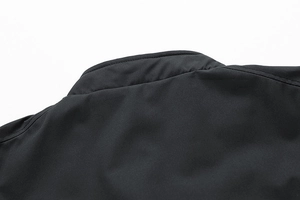 Close-up detail of the durable collar and precise stitching on the black outdoor jacket