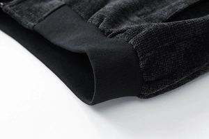 Macro shot of ribbed cuffs and textured waffle knit fabric on a charcoal men's jacket
