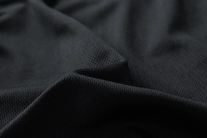 Detailed macro view of black breathable mesh fabric texture for lightweight sports jackets