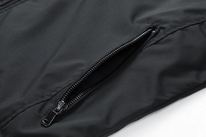 Detailed macro view of the sleek black jacket side pocket with a metallic zipper closure