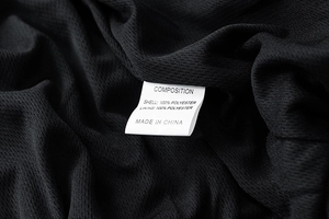 Detailed close-up of breathable black polyester mesh lining and fabric material label