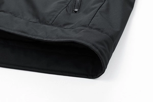 Detail view of the sleek black jacket featuring premium windproof fabric and hidden zipper pocket