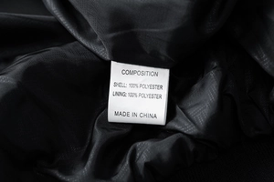 Detailed view of the 100% polyester fabric composition and care label inside the jacket