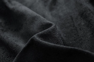 Detailed macro view of high-quality black knitted fabric texture with visible fibers
