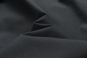 Close-up of premium black jacket fabric showing high-density texture and matte finish