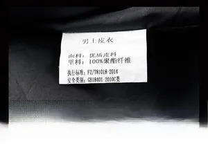 Détail de l'étiquette d'entretien et de la composition du tissu d'une veste en cuir PU homme
