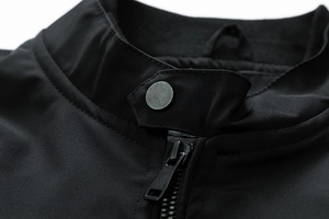 Macro detail of men's lightweight flight jacket collar with metallic snap and zipper