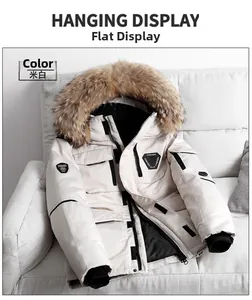 Detail of a thick cream winter parka with a large fluffy faux fur collar on a sofa