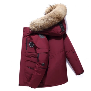 Dark red winter parka with fluffy fur hood and utility pockets in a side view display