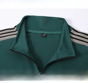 Detail of dark green tracksuit jacket featuring stand-up collar and striped shoulder tape