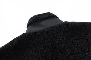 Close-up of black fleece jacket showing stand collar texture and fabric stitching