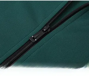 Close-up of premium black metal zipper and dark green ribbed knit fabric on men's tracksuit