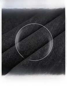 Vue détaillée de la texture du tissu denim noir haute densité avec icônes d'entretien