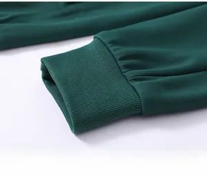 Close-up of elastic ribbed cuffs on a dark green tracksuit showing fabric texture