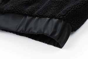 Detail shot of the elastic hem on a black lamb wool jacket with soft textured fleece fabric