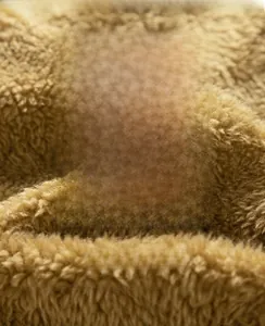 Close-up of soft brown faux shearling fabric with long fibers for winter warmth
