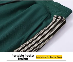 Detail view of dark green sports pants featuring ribbed elastic waist and three stripes