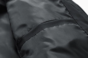 Close-up of black fleece jacket lining showing high-quality inner pocket stitching details