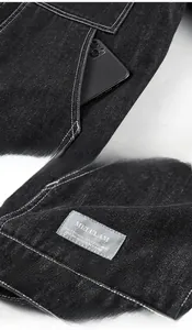 Détail de veste de travail en denim foncé avec poches renforcées et surpiqûres contrastées