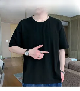 Detail of a black crewneck short sleeve T-shirt with a relaxed drop shoulder fit on a model