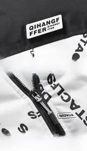 Detailansicht der schwarz-weißen Kontrastjacke mit Buchstaben und robustem Reißverschluss
