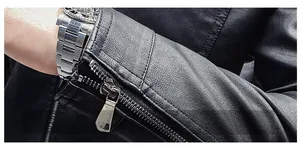 Close-up of black biker jacket featuring litchi grain texture and metal zipper cuffs