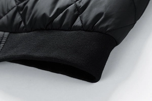 Detailaufnahme der schwarzen Rautensteppung und des elastischen Rippbündchens