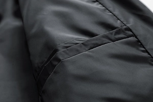 Detail der schwarzen Steppjacke mit Innentasche und glattem synthetischem Innenfutter