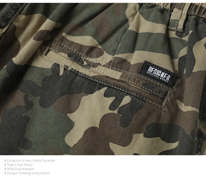 Dettaglio macro dei pantaloni cargo mimetici con vita elastica ed etichetta designer