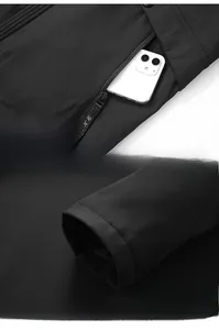 Detail of zippered pocket holding a smartphone and windproof cuffs on a black jacket