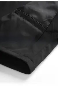 Detailed view of the jacket's inner pocket and hem stitching on black windbreaker