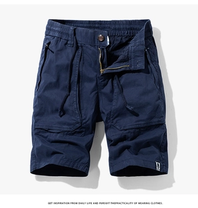 Détail du short cargo bleu marine avec poches à rabat et étiquette FASHION blanche