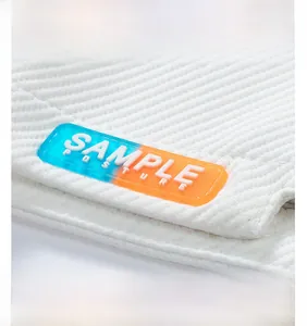 Close-up of Sample Posture rubber label on white wide-leg casual shorts with twin stitching